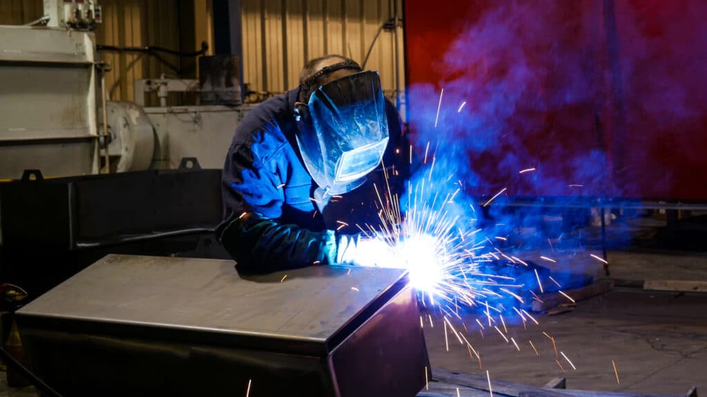 An image of a welder wearing a mask while welding.